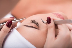 64108695 - my favorite procedure. close up of eyelash extension procedure in beauty salon for attractive woman